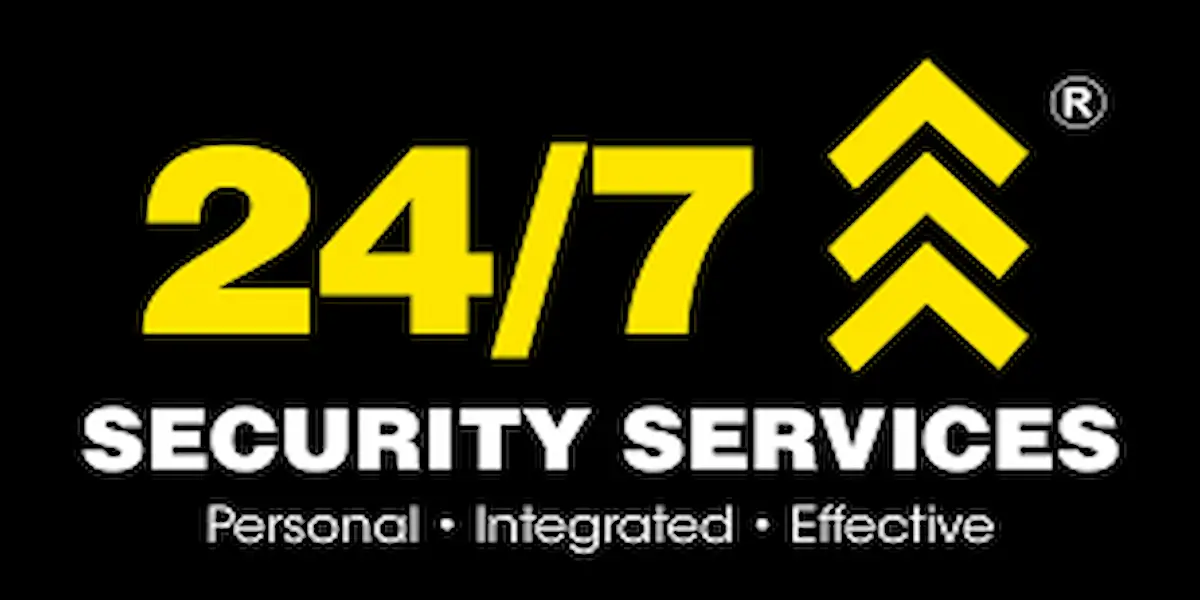 Professional security guard standing in front of a 24/7 Security patrol vehicle, representing career opportunities.